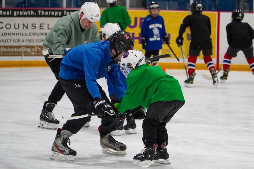 A coach guiding a camper through a turn at the boards