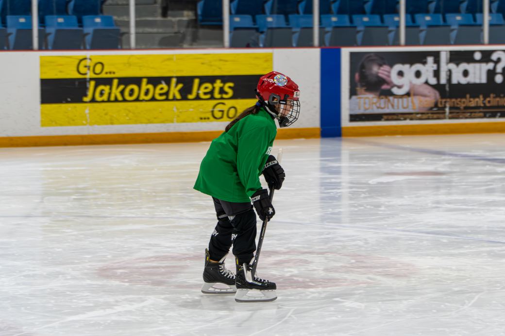 A young skater making their way across open ice on their own