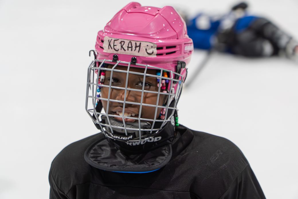 A camper in a pink cage helmet looking towards the camera