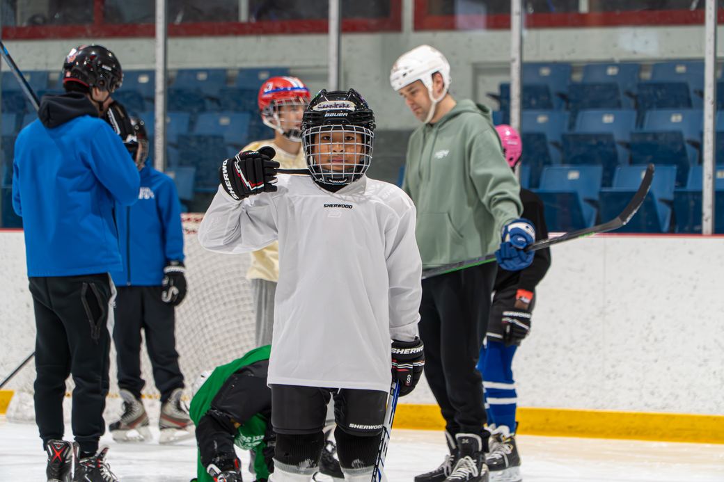 A row of campers in helmets listening to instructions