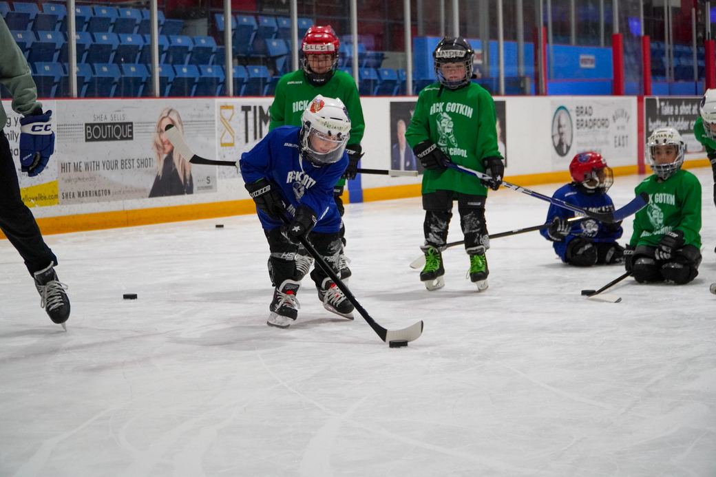 Campers with sticks raised in the air during a drill