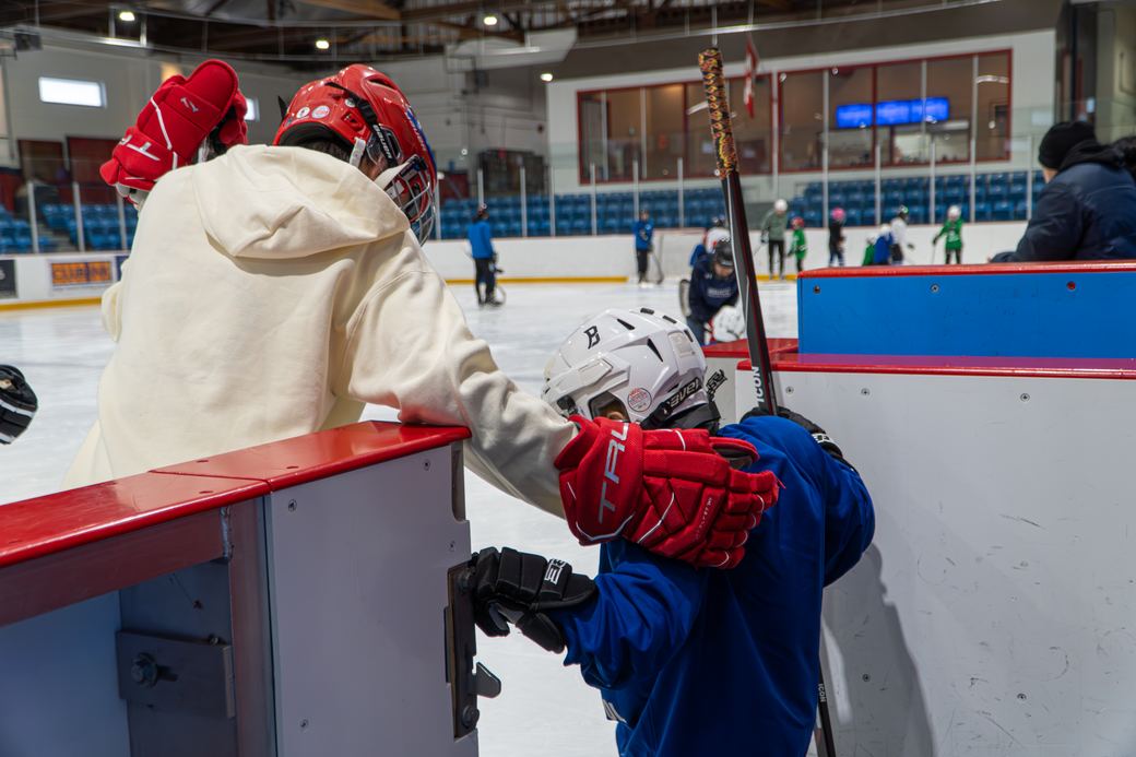 A helmet being fitted onto a camper leaning over the boards