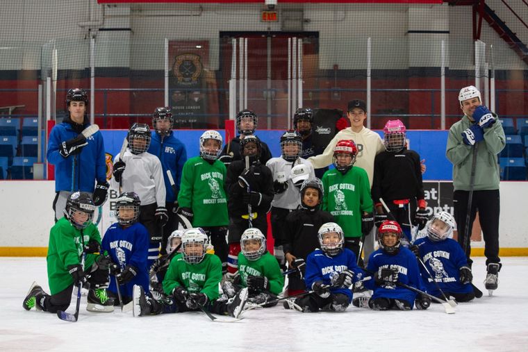 The full March 2026 camp group gathered on the ice with coaches and volunteers