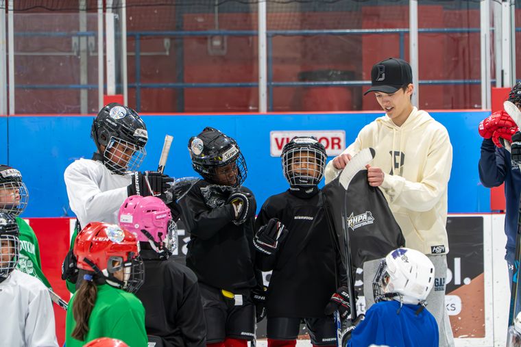Volunteers handing equipment bags to campers along the boards