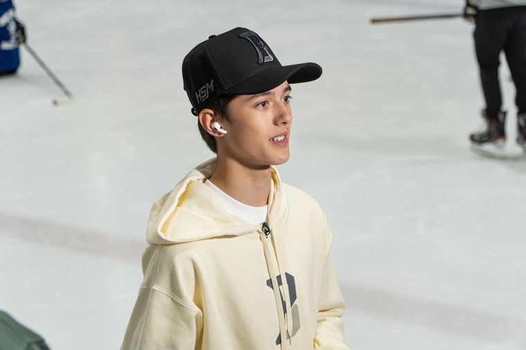 Andrew Adair on the ice in a cream hoodie during a camp session