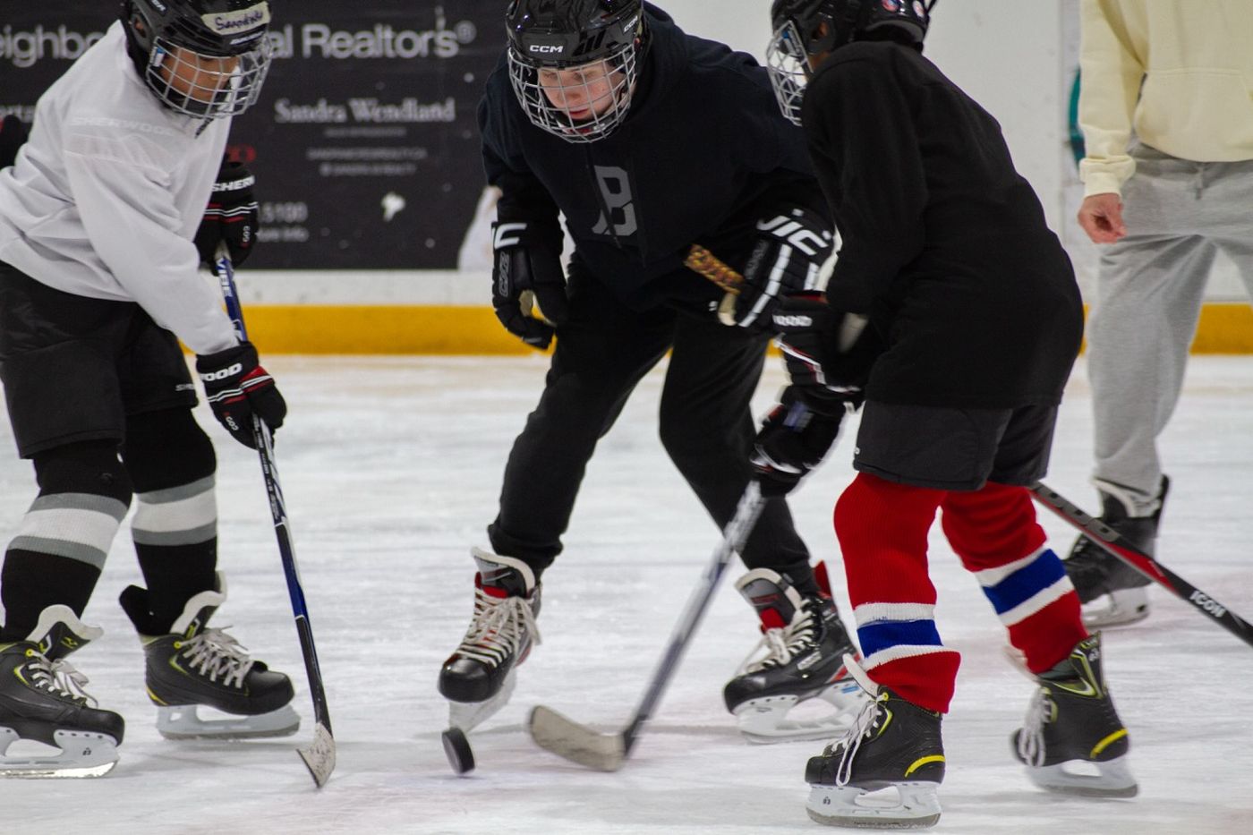 Older campers lined up for a face-off in a small-area game at one end of the rink
